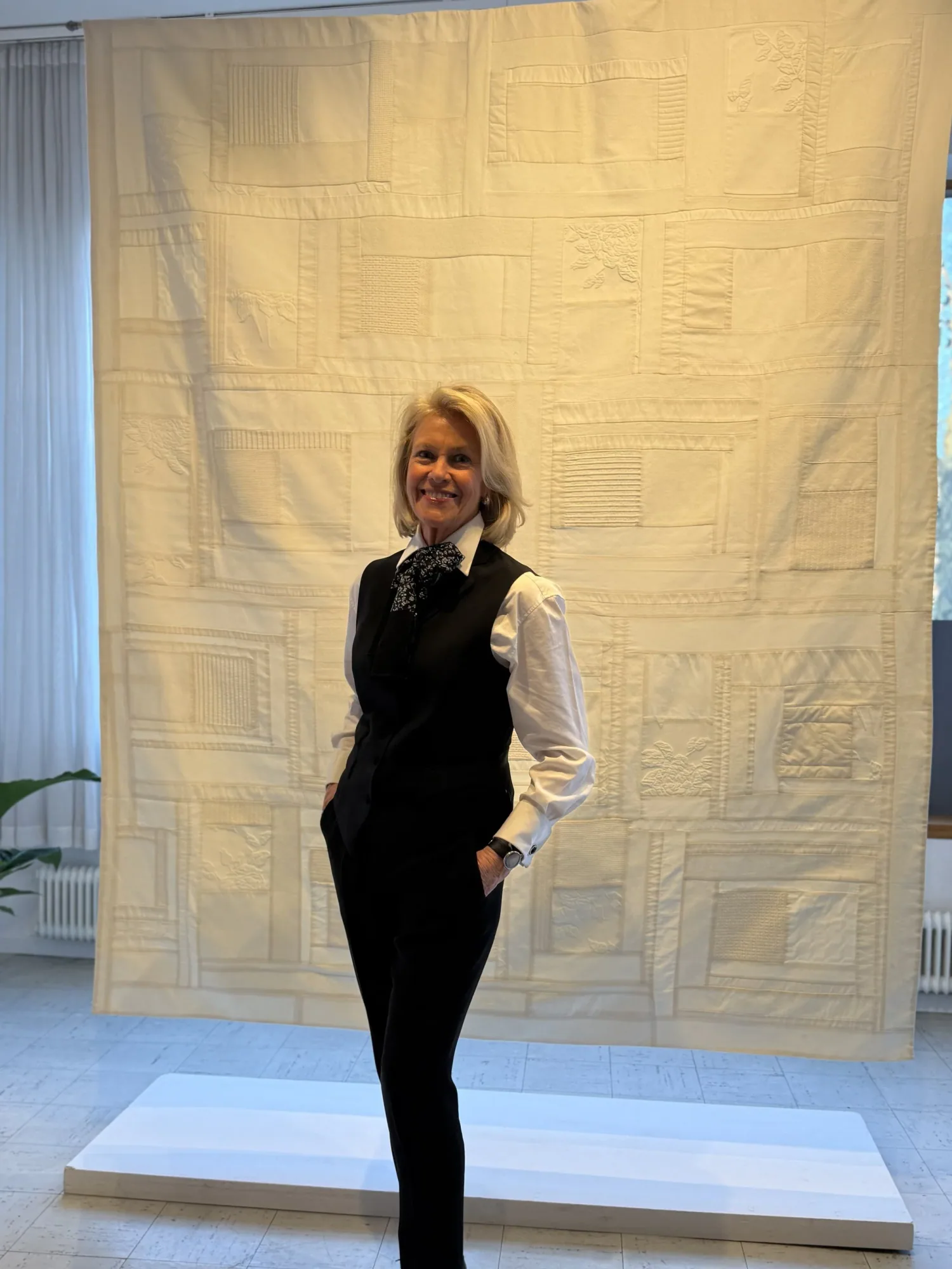 Anna Maria Eiderbrant framför en vit väggbonad